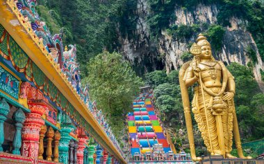 Kuala Lumpur, Malezya-17 Nisan 2023: Ziyaretçiler, açık uçlu mağaraya ve tapınağın içindeki güzel mimarisine hayran olmak için renkli merdivenleri tırmanıyor..