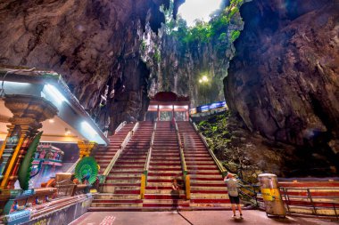 Kuala Lumpur, Malezya-17 Nisan 2023: Ziyaretçiler mağara kompleksinin içinde, 1920 'de inşa edilen güzel tapınağa ve muazzam kireçtaşı duvarların muhteşem doğal güzelliğine hayranlıkla bakıyorlar..