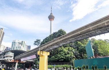 A modern efficient integrated transport network,running atop tall concrete pillars,winding in between modern skyscrapers,connecting many areas of central KL City and its International airport. clipart