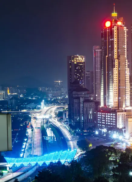 stock image Illuminated by colorful lights,Saloma Link changes colors randomly,with the Muslim Cemetery in the foreground.A motorway and Klang river run by,under the pedesterian bridge,next to modern buildings.