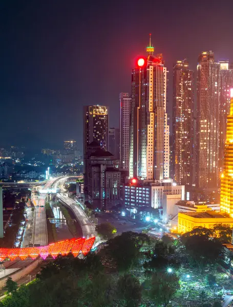 stock image Illuminated by colorful lights,Saloma Link changes colors randomly,with the Muslim Cemetery in the foreground.A motorway and Klang river run by,under the pedesterian bridge,next to modern buildings.