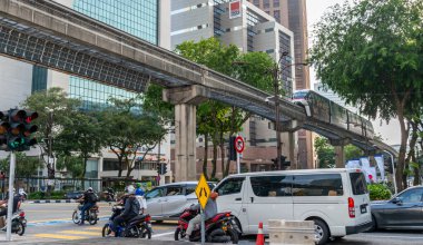 Kuala Lumpur, Malezya 20 Nisan 2023: Modern, verimli bir entegre ulaşım ağı, Klang Vadisi Hızlı Geçiş metro sistemi, modern binalar arasında, yoğun trafiğin üzerinde zahmetsizce esen rüzgarlar.