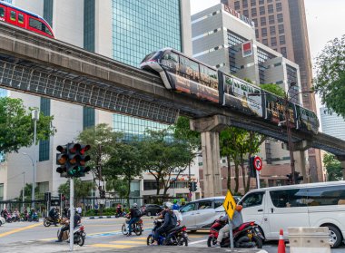 Kuala Lumpur, Malezya 20 Nisan 2023: Modern, verimli bir entegre ulaşım ağı, Klang Vadisi Hızlı Geçiş metro sistemi, modern binalar arasında, yoğun trafiğin üzerinde zahmetsizce esen rüzgarlar.