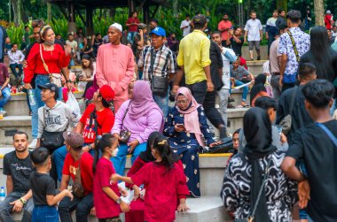 Kuala Lumpur,Malaysia-April 23 2024: Within KLCC Park,at the esplanade outside of Suria KLCC Mall,visitors await the upcoming musical fountains display,as sunset approaches. clipart
