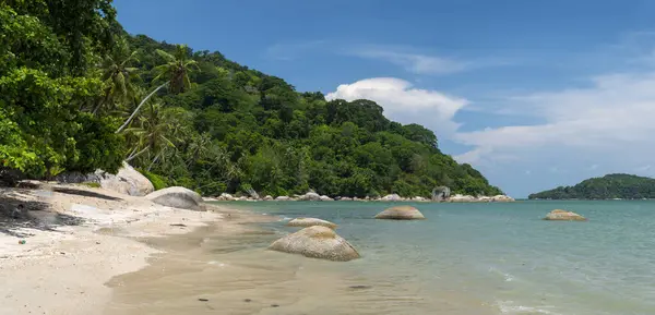 stock image A hidden gem in Penang,a paradise travel location,referred to as Secret Beach,beautiful sands and coconut palm trees lining the beach,gentle waves and calm sea,blue skies and sunshine.