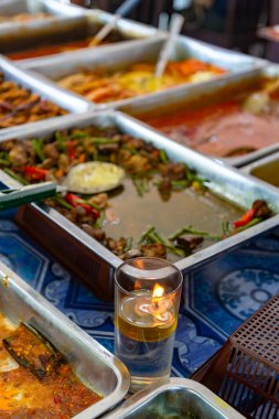 Yerel bir restoranda her öğle yemeğinde, yeni hazırlanmış, lezzetli geleneksel yemekler aç yolcuları tavuklar, sosisler, sebzeler, yumurtalar, salatalar, fındıklar ve soslar dahil olmak üzere cezbetmek için düzenlenir..