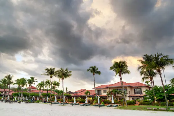 stock image Clouds drifting over the long stretch of coastline,at dusk,with holiday bungalows and palm trees line the fine white sands,a prime tourist destination on the southwest coast of Langkawi.