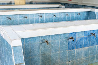 Bir Wadhu tesisi, ibadetten önce yıkanmak için ayrılmış bir yer. Temizlik için bir abdest yeri, birden fazla musluğu olan mavi fayanslı çamaşır alanları..