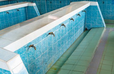 Bir Wadhu tesisi, ibadetten önce yıkanmak için ayrılmış bir yer. Temizlik için bir abdest yeri, birden fazla musluğu olan mavi fayanslı çamaşır alanları..