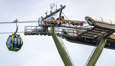 Kablolu TV araçları, ağaçlarla kaplı dağ tepelerinin üzerinden ve çevresindeki güzel manzaralarla ünlü şehir simgesine gidip geliyor. Langkawi 'nin sahil ve dağ manzarasının.