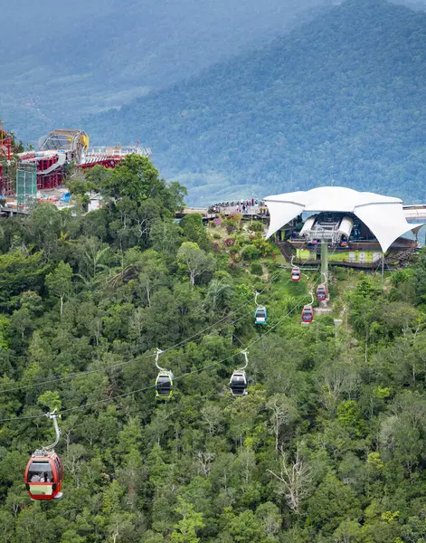 stock image Cable held gondolas,carrying tourists visiting the Sky Bridge,passing over the high forested peaks and dramatic landscape of the second highest mountain in Langkawi.