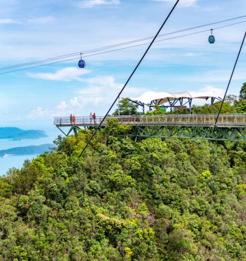Langkawi Adası, Malezya-Mayıs 02-2023: Adanın en yüksek ikinci dağı olan Mat Cincang 'ın tepelerine tünemiş olan Gökyüzü Taksisi, bir gondol asansörü ve başlıca turistik ilgi merkezi, turistlerin üzerinde yer almaktadır..
