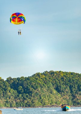 Langkawi Adası, Malezya-Mayıs 05: 2023: Gökyüzünde ve denizin üstünde uçan turistler, öğleden sonra sürat tekneleriyle çekilen paraşütçüler için ödeme yapıyorlar..