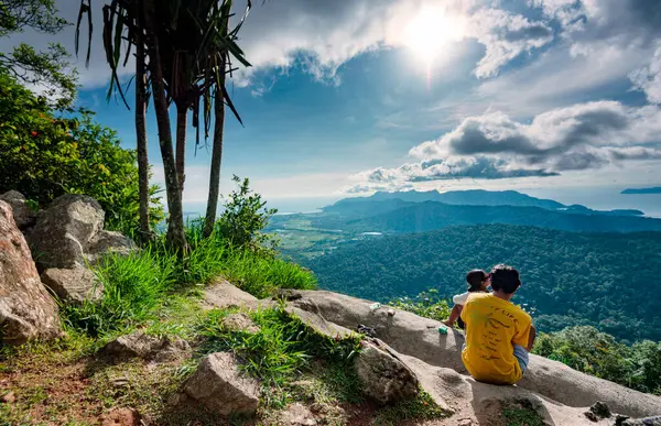 stock image Langkawi,Malaysia-May 05 2023:People take in the spectacular panoramic scenery,from the edge of a high cliff,in the center of the Island,overlooking the tropical landscape and small islands beyond.