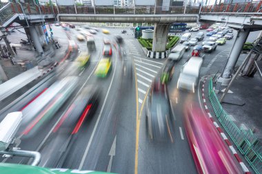 Yoğun şehir trafiğinin bulanık hareketi, kaldırımın altında hızla ilerlerken, aşağıdaki kalabalık şehrin üzerinden hızla geçen yüksek, yolcu dolu bir gökyüzü treni....