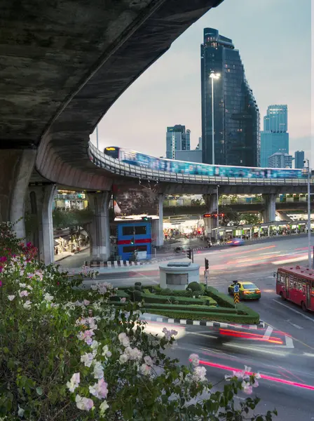 stock image At sunset,during rush hour,the blurred movement of vehicles and a passenger filled train,circulates the busy city center roundabout.