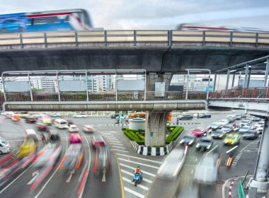 Bangkok, Tayland-08 Mayıs 2023: Bir motosikletli taksi şoförü sabırla oturur, hareketsiz, etrafını saran yoğun trafik çizgilerine ayak uydurmayı bekler,.