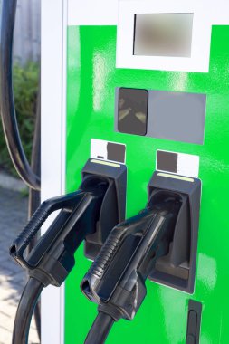 EV şarj noktası, bir tren istasyonunun otoparkında, kamu elektrikli aracının park yerinin yanında duruyor..
