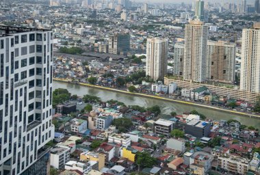 Manila, Filipinler-16 Mayıs 2023: Pasig Nehri, eski ve modern, büyük ve küçük mimari tarzların bir karışımı arasında büyük metropol boyunca akar..