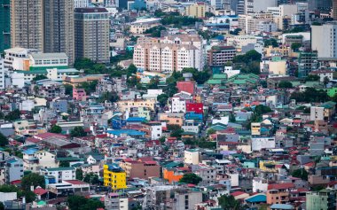 Manila, Luzon, Filipinler-19 Mayıs 2023: Batan güneş, yoğun, yoğun nüfuslu, yerleşim ve kurumsal yapıların çevresel karışımı olan şehir metropolüne sıcak bir ışık tutuyor.