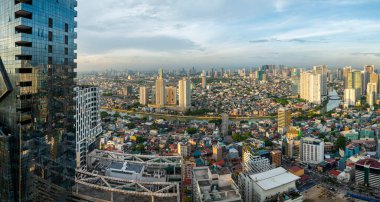 Manila, Filipinler-16 Mayıs 2023: Pasig Nehri günbatımında uzun modern mimari ve fakir yerleşim alanlarıyla çevrili olarak başkentten geçer..