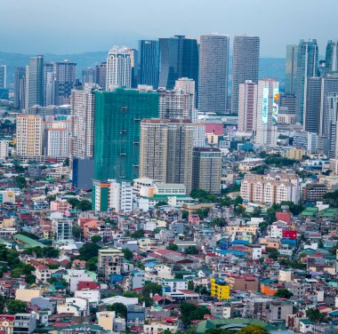 Manila, Luzon, Filipinler-19 Mayıs 2023: Batan güneş, yoğun, yoğun nüfuslu, yerleşim ve kurumsal yapıların çevresel karışımı olan şehir metropolüne sıcak bir ışık tutuyor.