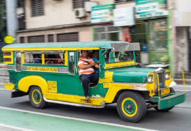 Manila, Filipinler-13 Ocak 2023: Filipin kültürünün ve sanatının sembolü olan ve ülkenin en popüler ve kalabalık toplu taşımacılığı olan renkli, kırsal araçlar sokaklarda koşturuyor.