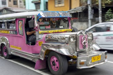 Manila, Filipinler-13 Ocak 2023: Filipin kültürünün ve sanatının sembolü olan ve ülkenin en popüler ve kalabalık toplu taşımacılığı olan renkli, kırsal araçlar sokaklarda koşturuyor.