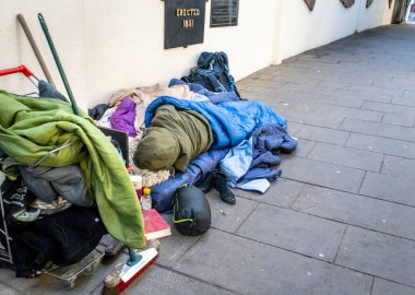 Worcestershire İngiltere-22 Kasım 2024: Birkaç eşyası eski yatak ile kaplı iki fakir yetişkin ana cadde mağazaları arasında dar bir yaya geçidi boyunca uzandı.