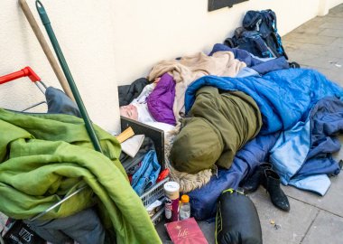 Worcestershire İngiltere-22 Kasım 2024: Birkaç eşyası eski yatak ile kaplı iki fakir yetişkin ana cadde mağazaları arasında dar bir yaya geçidi boyunca uzandı.