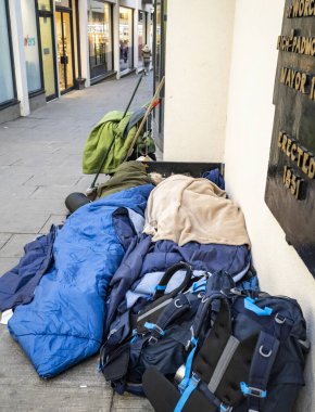 Worcestershire İngiltere-22 Kasım 2024: Birkaç eşyası eski yatak ile kaplı iki fakir yetişkin ana cadde mağazaları arasında dar bir yaya geçidi boyunca uzandı.