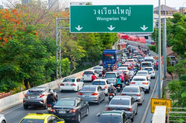 Tayland-15 Mayıs 2024: Yoğun öğleden sonra kuyrukları, bitkiler, çiçekler, yeşil ağaçlar ve faunayla dolu çevre dostu yolların altında yavaşça ilerler.