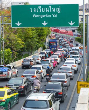 Tayland-15 Mayıs 2024: Yoğun öğleden sonra kuyrukları, bitkiler, çiçekler, yeşil ağaçlar ve faunayla dolu çevre dostu yolların altında yavaşça ilerler.