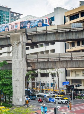 Tayland-Temmuz 03: 2024: Bir BTS Skytrain, Ratchadamri Yolu üzerinde, araçlar ve yayalar Bangkok şehir merkezinde ilerlerken,.