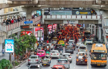 Tayland-Temmuz 03: 2024: Hokkabazlık yapan öğleden sonra trafiği, banliyö sakinleri yüksek yaya yollarında, araçların akışının üzerinde yürürken yavaş ilerliyor.