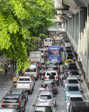 Tayland-Temmuz 03: 2024: Büyülü araç trafiği, halkı çeşitli dükkanlar ve yaya köprüleriyle güvenli bir şekilde bağlayan, yüksek doğrusal yürüyüş yolunun altında yavaşça ilerliyor.