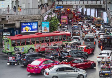 Tayland-Temmuz 03: 2024: Hokkabazlık yapan öğleden sonra trafiği, banliyö sakinleri yüksek yaya yollarında, araçların akışının üzerinde yürürken yavaş ilerliyor.