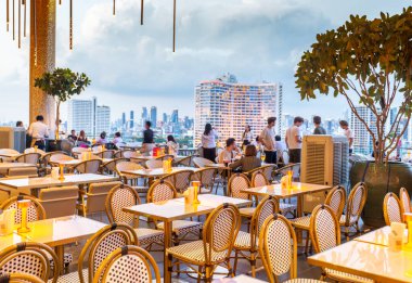 Bangkok, Tayland-02 Temmuz 2024: Tasana Nakorn Terrace, akşam yaklaşırken, alışveriş merkezi binasındaki yedi yemek alanından biri olan 6. katta, Chao Phraya Nehri üzerinde etkileyici manzaralar sunuyor..