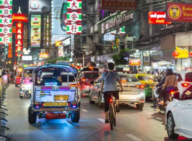 Tayland-3 Temmuz 2024: Bangkok 'un Çin mahallesinin gece manzarası, parlak ışıklar ve tabelalar, gösterişli pezevenkler Tuk-tuk' lar, gıda tezgahları, dükkanlar ve kalabalık ana caddede kuyruk oluşturan birçok insan.