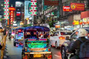 Tayland-3 Temmuz 2024: Bangkok 'un Çin mahallesinin gece manzarası, parlak ışıklar ve tabelalar, gösterişli pezevenkler Tuk-tuk' lar, gıda tezgahları, dükkanlar ve kalabalık ana caddede kuyruk oluşturan birçok insan.
