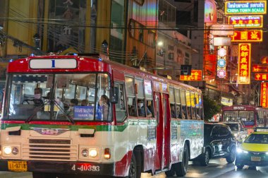 Tayland-3 Temmuz 2024: Bangkok 'un Çin mahallesinin gece manzarası, parlak ışıklar ve tabelalarla, gece geç saatlerde toplu taşıma servisleri kaldırımlardan geçerken, insanlarla dolup taşarken.