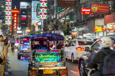 Tayland-3 Temmuz 2024: Bangkok 'un Çin mahallesinin gece manzarası, parlak ışıklar ve tabelalar, gösterişli pezevenkler Tuk-tuk' lar, gıda tezgahları, dükkanlar ve kalabalık ana caddede kuyruk oluşturan birçok insan.
