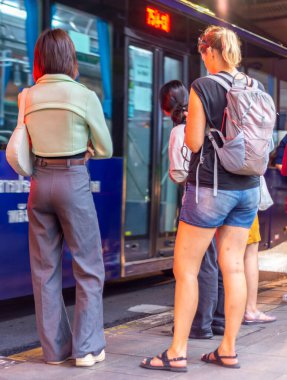 Bangkok, Tayland-Temmuz 04: 2024: Yoğun bir akşamın erken saatlerinde, insanlar otobüs duraklarında, metropol bölgelerinde çeşitli noktalara gitmek için dururlar..