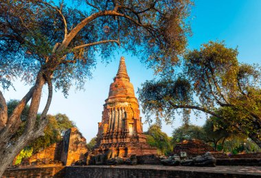 Wat Phra Si Santhe 'nin kendine özgü ve ünlü pagodaları, gün batımında, eski başkenti Siyam' ın ikonik kraliyet sarayının güzel topraklarında..