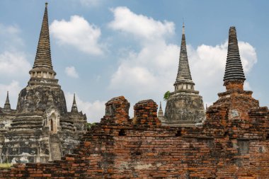 Wat Phra Si Santhe 'nin kendine özgü ve ünlü pagodaları, gün batımında, eski başkenti Siyam' ın ikonik kraliyet sarayının güzel topraklarında..