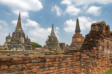 Wat Phra Si Santhe 'nin kendine özgü ve ünlü pagodaları, gün batımında, eski başkenti Siyam' ın ikonik kraliyet sarayının güzel topraklarında..