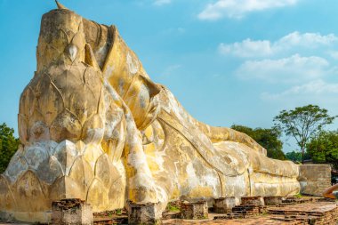 Öğleden sonra güneşinin altında, mavi gökyüzünün altında dinlenen Buda 'nın büyük taş heykeli, Bangkok yakınlarındaki eski antik Siyam tapınağı başkentinde popüler bir turizm merkezidir..