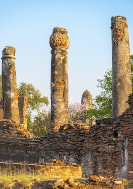 Tarihi bölgede, Budist pagoda ile birlikte antik duvarlar ve sütunlar günbatımının ışığında berrak mavi gökyüzü ile ağaçların arasında duruyordu..