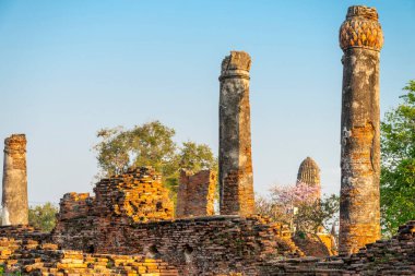 Tarihi bölgede, Budist pagoda ile birlikte antik duvarlar ve sütunlar günbatımının ışığında berrak mavi gökyüzü ile ağaçların arasında duruyordu..