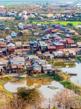 Öğleden sonra geç saatlerde, Phnom Kraom Tepesi Tapınağı 'ndan görülen su birikintilerinin yanında duran bölge, yağmur mevsiminde sular altında kalır..